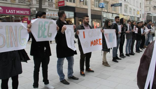 Eine Gruppe von Menschen demonstriert mit Schildern in einer Stadt.