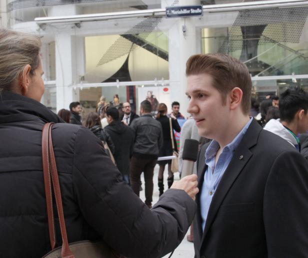 Ein Mann im Anzug wird auf der Mariahilfer Straße interviewt.