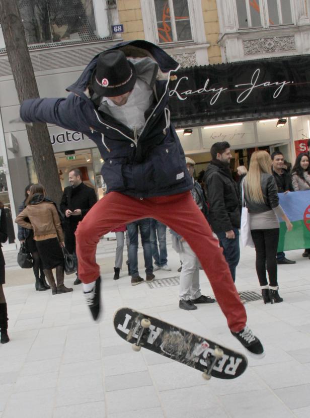 Ein Mann springt mit einem Skateboard in der Luft vor einem Geschäft.