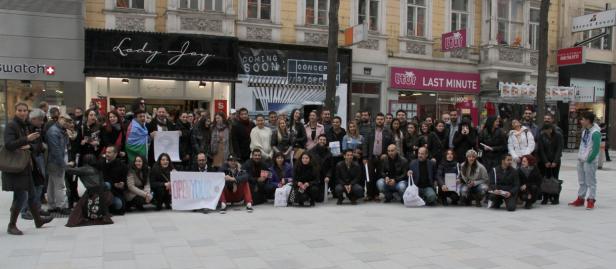 Eine Gruppe von Menschen posiert vor einer Ladenzeile für ein Foto.