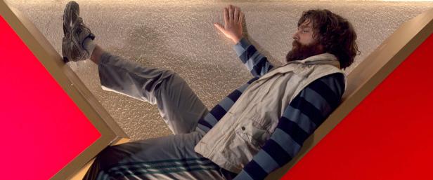 Zach Galifianakis liegt in einem ungewöhnlichen Winkel auf einer Art Bühne.