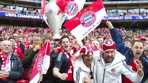 Jubelnde Fans des FC Bayern München feiern mit dem Pokal in Wembley 2013.