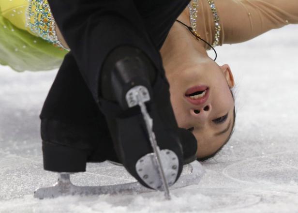 Eine Eiskunstläuferin während einer Drehung auf dem Eis.