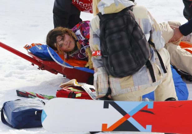 Eine verletzte Snowboarderin wird auf einer Trage abtransportiert.