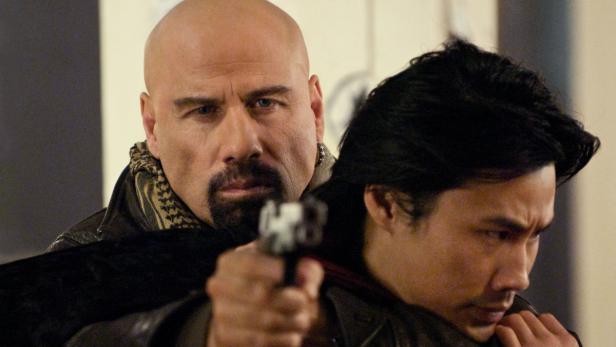 John Travolta zielt mit einer Waffe auf den Kopf einer anderen Person.