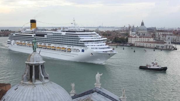 Die „Costa Fascinosa“ fährt in Venedig an einem Schlepper vorbei.