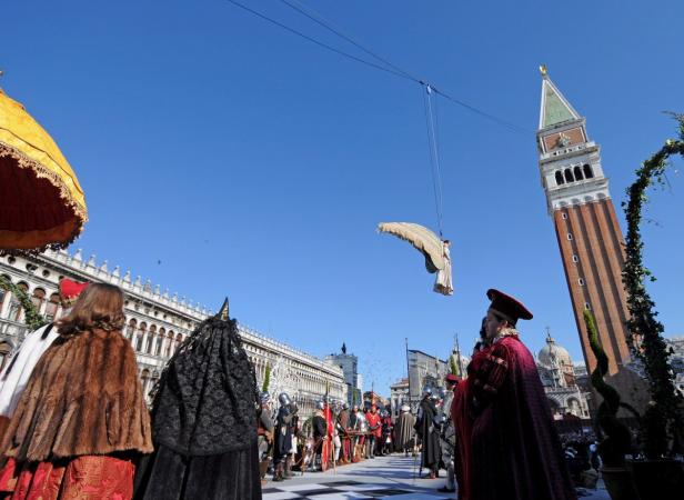 Beim Karneval in Venedig schwebt eine als Engel verkleidete Person über den Markusplatz.