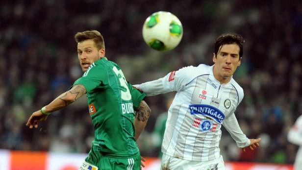 Zwei Fußballspieler kämpfen um den Ball während eines Spiels.