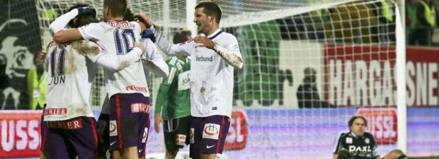 Fußballspieler feiern ein Tor auf dem Spielfeld.