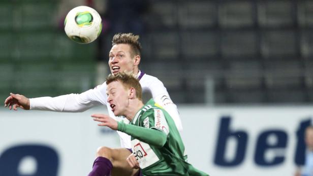 Zwei Fußballspieler kämpfen um einen Ball in der Luft.