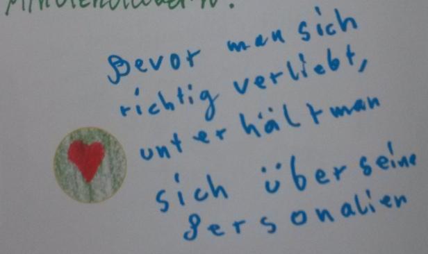 Ein handgeschriebener Text auf Deutsch mit einem kleinen Herzaufkleber.