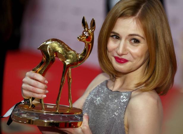 Die Schauspielerin Aylin Tezel hält eine goldene Bambi-Statue.