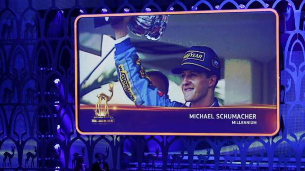 Ein Bildschirm zeigt Michael Schumacher mit einem Pokal und dem Schriftzug „Millennium“.