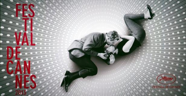 Ein Paar liegt vor dem Hintergrund des Filmfestivals von Cannes und küsst sich.