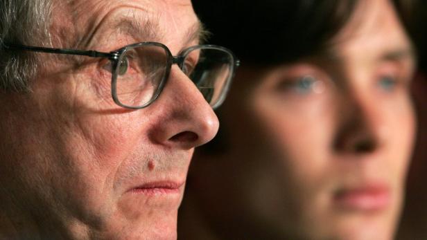 Nahaufnahme von zwei Personen, eine mit Brille im Fokus, die andere unscharf im Hintergrund.