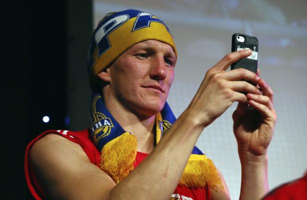 Bastian Schweinsteiger macht ein Foto mit seinem Smartphone.