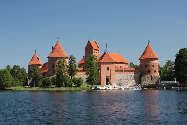 Das Schloss Trakai mit seinen roten Ziegeldächern liegt an einem See.