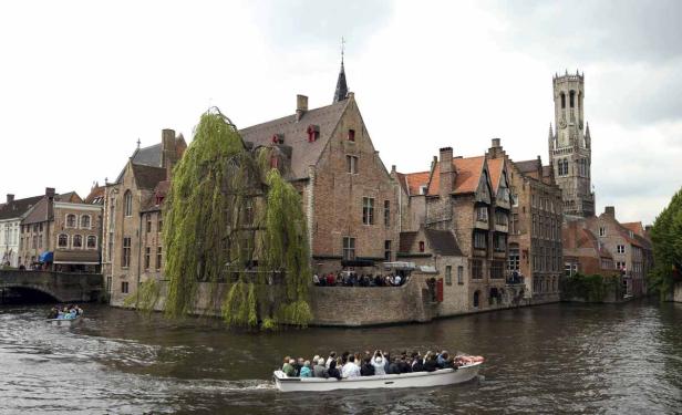 Eine Bootsfahrt auf einem Kanal in Brügge, Belgien, mit Blick auf historische Gebäude.