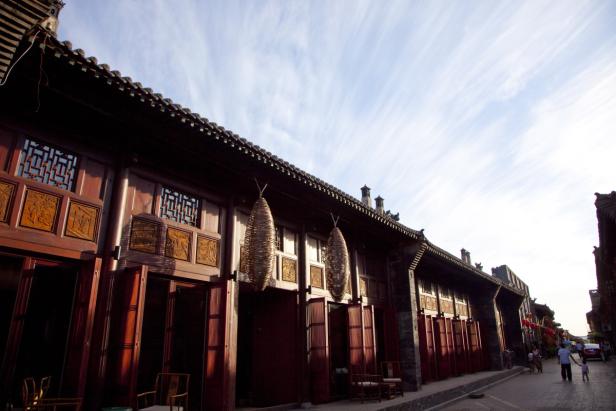 Eine traditionelle chinesische Straße mit Holzbauten und Laternen.