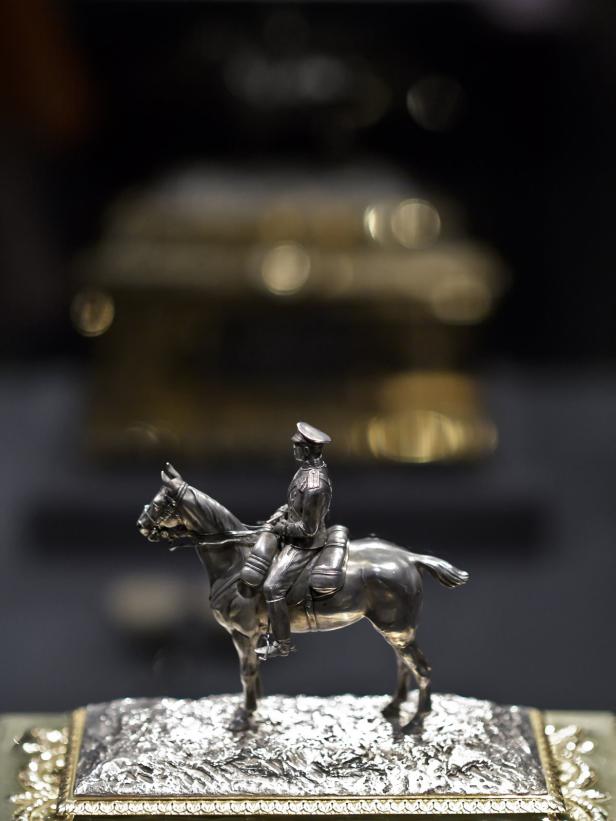 Eine silberne Statuette zeigt einen Offizier auf einem Pferd.