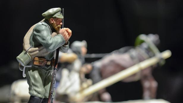 Eine Miniaturfigur eines Soldaten in Uniform mit Gewehr und Gepäck.