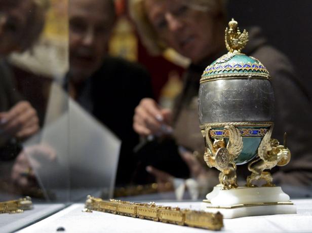 Ein Fabergé-Ei und ein Miniaturzug werden in einer Vitrine ausgestellt.