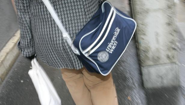 Eine Person trägt eine blaue Tasche der Universität Wien.