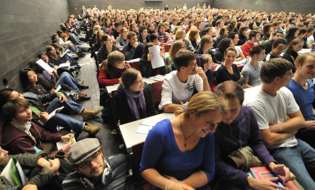 Ein voll besetzter Hörsaal mit Studierenden während einer Vorlesung.