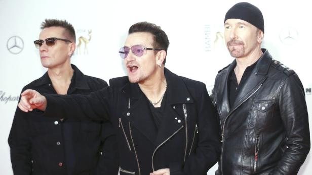 Die Band U2 posiert auf einem roten Teppich.