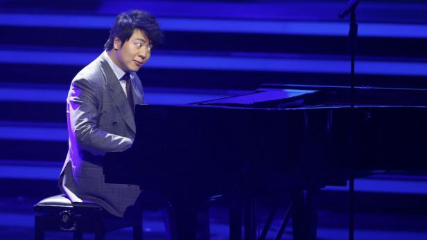 Lang Lang spielt Klavier auf einer Bühne mit blauem Licht.