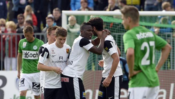 Fußballspieler umarmen sich auf dem Spielfeld.
