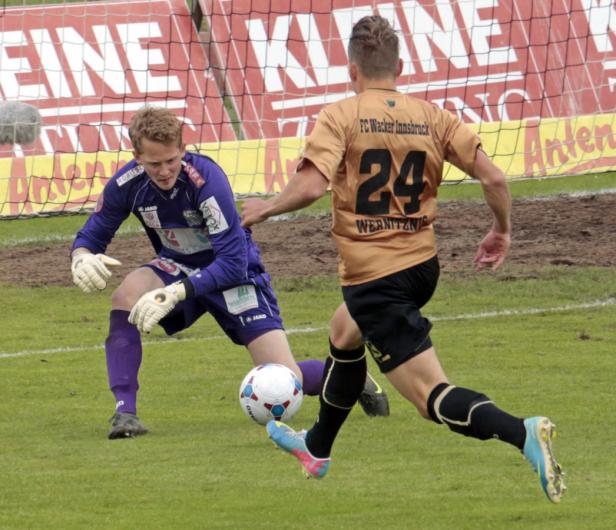Ein Fußballspieler von FC Wacker Innsbruck schießt auf das Tor, das vom Torwart verteidigt wird.