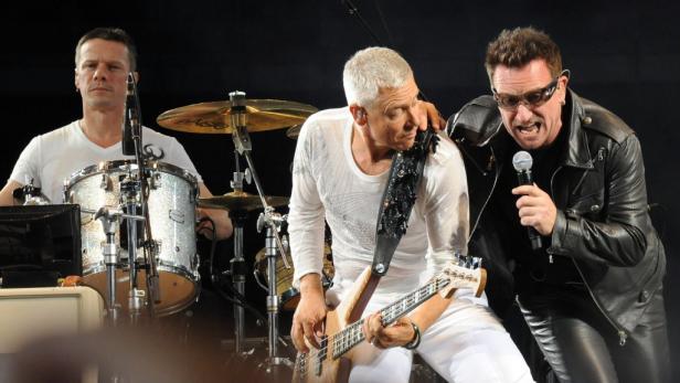 U2 mit Leadsänger Bono Vox (rechts) Die Band U2 tritt live auf der Bühne auf.