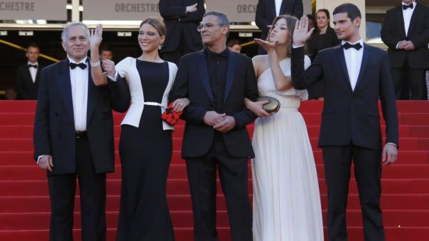 Eine Gruppe von Personen posiert auf einem roten Teppich.