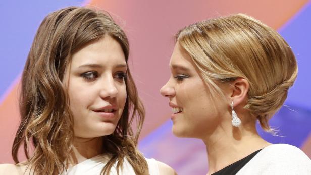 Zwei junge Frauen stehen nebeneinander und unterhalten sich.