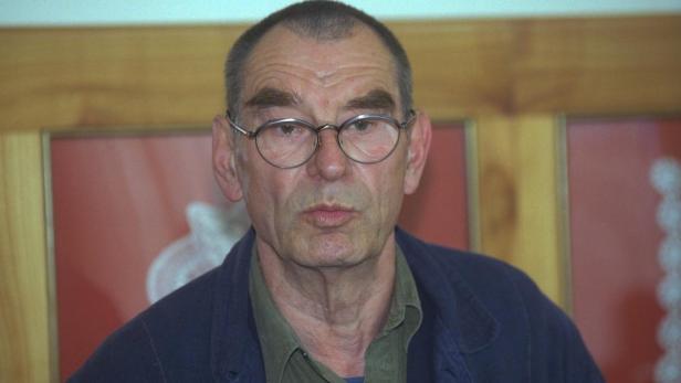 Ein Mann mit Brille und blauem Hemd blickt in die Kamera.