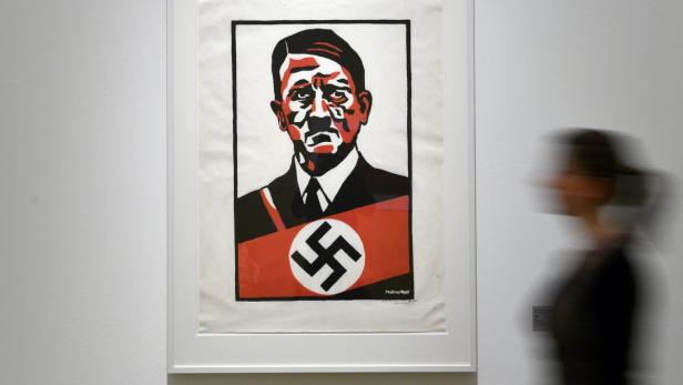 Ein Porträt von Adolf Hitler mit Hakenkreuz auf rotem Grund in einem Museum.