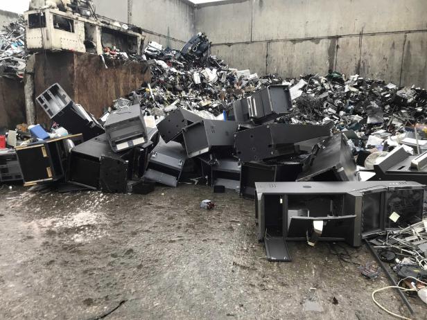 Ein Schrotthaufen aus Computern und Elektronik in einer Recyclinganlage.