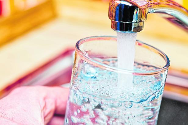 Filling up a glass with water from kitchen tap POV