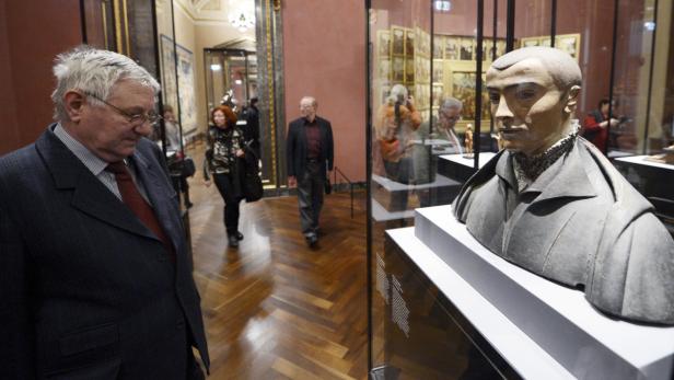 Ein Mann betrachtet eine Büste in einem Museum.