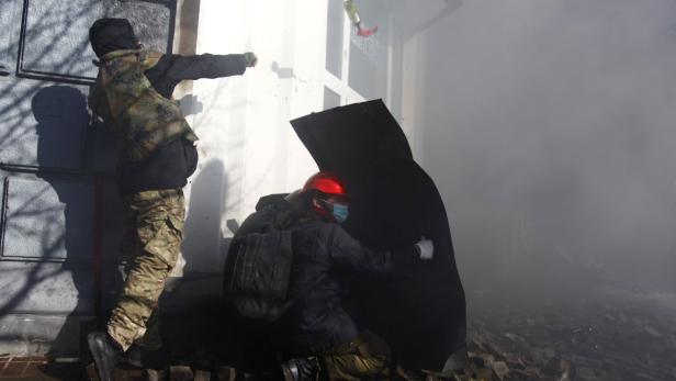 Zwei Personen während einer Auseinandersetzung, eine wirft einen Gegenstand, die andere schützt sich mit einem Schild.