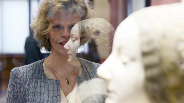Eine Frau betrachtet eine Marmorbüste in einem Museum.