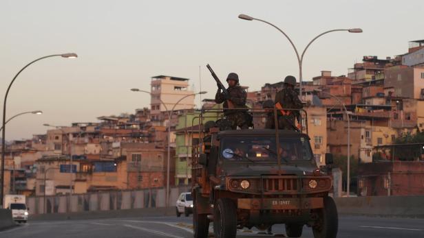 Soldaten patrouillieren in einem Militärfahrzeug vor einer Favela in Rio de Janeiro.