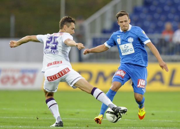 Zwei Fußballspieler kämpfen um den Ball während eines Spiels.