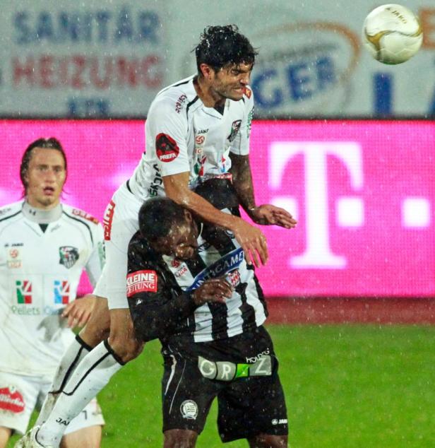 Zwei Fußballspieler kämpfen bei einem Fußballspiel um den Ball.