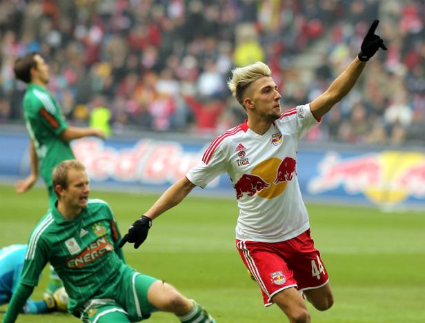 Ein Fußballspieler in weiß-rotem Trikot jubelt mit erhobenem Zeigefinger.