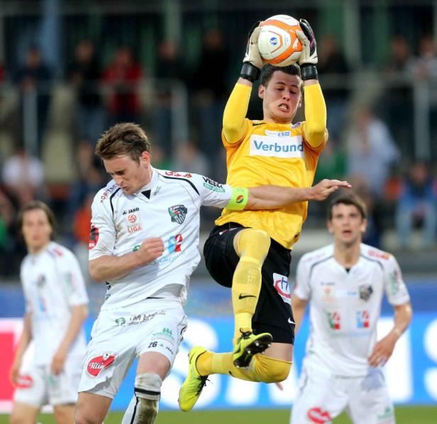 Ein Torwart fängt den Ball während eines Fußballspiels.