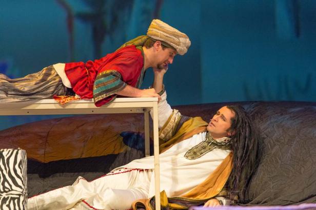 Zwei Männer in Kostümen auf einer Bühne während einer Theateraufführung.