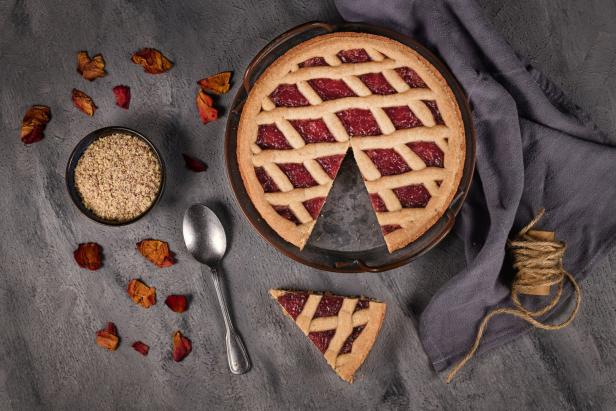Eine Linzer Torte mit einem herausgenommenen Stück auf einem Teller.