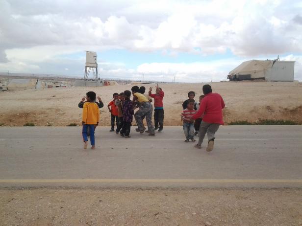Eine Gruppe Kinder spielt auf einer Straße in einem Flüchtlingslager.